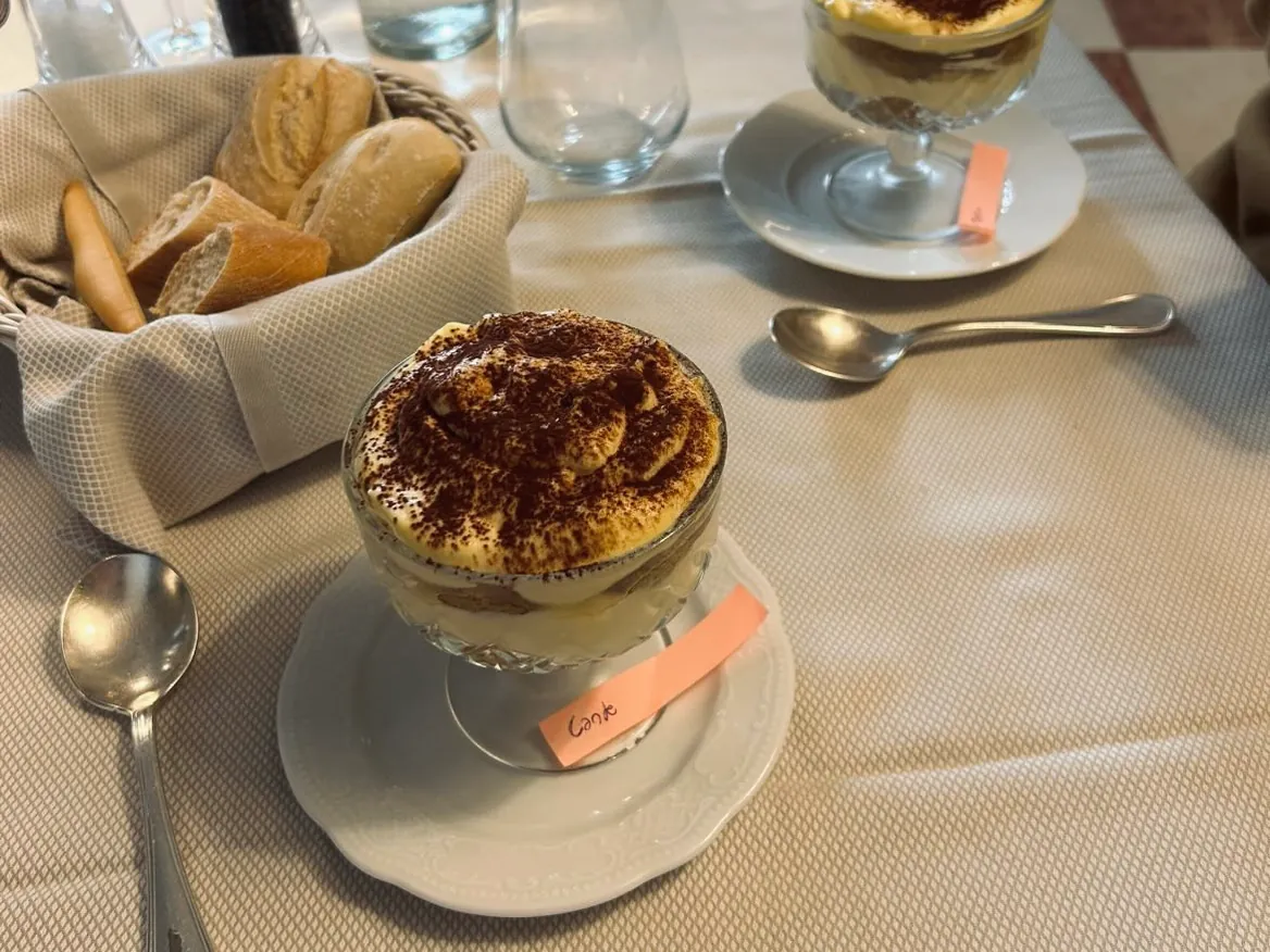 Glasses of tiramisù dusted with cocoa, served at the table